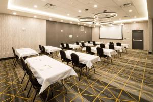 a conference room with tables and chairs and a whiteboard at Holiday Inn - Kalamazoo West, an IHG Hotel in Kalamazoo