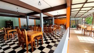 Supsangdao Resort في شاطيء آونانغ: مطعم بطاولات وكراسي خشبية على أرضية متقاطعة