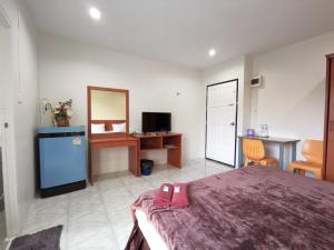 a bedroom with a bed with a pink purse on it at Ban Kaew Guesthouse Songkhla in Songkhla