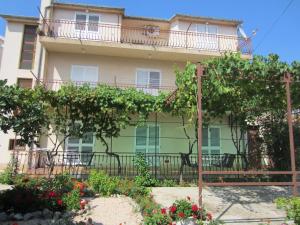 un immeuble d'appartements avec un balcon et des fleurs dans l'établissement Ivic Apartments Vodice Croatia, à Vodice