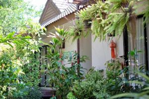 una casa con plantas y una boca de incendios roja en Kittawan Home&Gallery en Chiang Mai