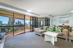 a living room with a couch and a balcony at Victoria Square Apartments in Gold Coast