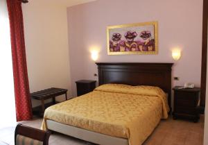 1 dormitorio con 1 cama y una foto en la pared en Hotel Vittorio Emanuele en Floridia