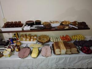 a table topped with lots of different types of food at Hotel Avenida - Hotel do Morais - Salto do Lontra in Salto do Lontra