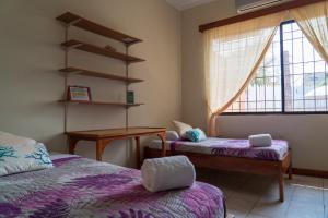 a room with two beds and a table and a window at Mare Mio in Puerto Baquerizo Moreno