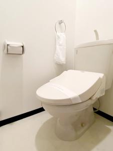 een badkamer met een toilet en een handdoek aan de muur bij OUCHI HOTEL Higashi-Hiratsuka #201 in Hiroshima