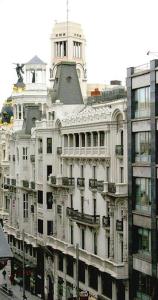 un grand bâtiment blanc avec une tour en haut dans l'établissement Hostal Delfina, à Madrid