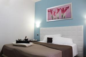 a bedroom with a large bed with pink flowers on the wall at Hotel Vittorio Emanuele in Floridia