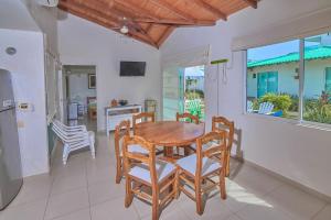 cocina y comedor con mesa de madera y sillas en Cabaña Coveñitas 3, en Coveñas