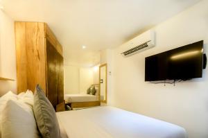 a bedroom with a bed with a tv on the wall at Zuzuni Boutique Hotel in Boracay
