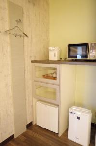 a kitchen with a counter with a microwave and a refrigerator at Bar 39 in Higashihiroshima