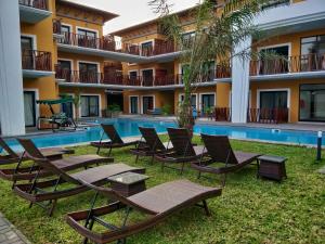 a resort with chairs and a swimming pool at Apartment E14, Forest View Apartments in Kololi