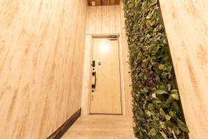 un couloir avec une porte et un mur vert dans l'établissement Guest House GORILLA!, à Osaka