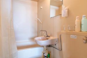 a bathroom with a sink and a shower at Uhome Ueno Apartment 4 in Tokyo