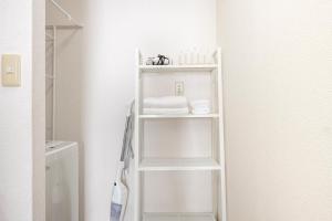 a white shelf in a bathroom next to a toilet at Uhome Ueno Apartment 4 in Tokyo