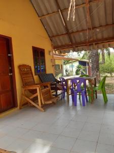 a patio with a table and chairs on a house at Som PalmGarden in Ko Lanta