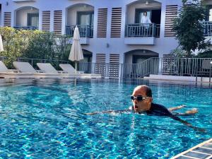 a man in a swimming pool in a hotel at Damrei Angkor Hotel in Siem Reap
