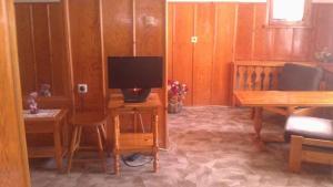 a living room with a tv and a desk with a computer at Matsureva House - Pri Ivan in Bansko