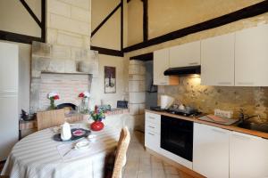 a kitchen with white cabinets and a table in a room at Les Gîtes de La Treille in Montagrier