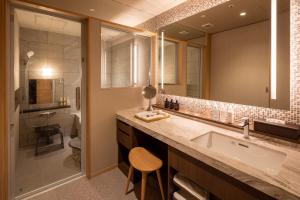 a bathroom with a sink and a large mirror at Hotel Wakamizu in Takarazuka