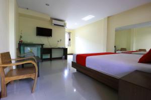 a bedroom with a large bed and a television at OYO 547 Happy Home in Bangkok