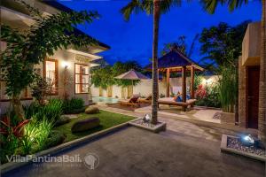 un patio trasero de una casa con cenador en Villa Pantina Bali, en Ungasan