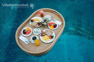 una bandeja de comida en una balsa en el agua en Villa Pantina Bali, en Ungasan