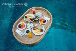 a tray of food on a raft in the water at Villa Pantina Bali in Uluwatu