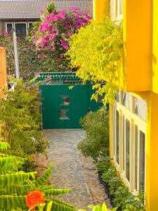 a garden with flowers and a green door at Homestay in Tay Ninh in Tây Ninh