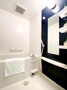 a white bathroom with a sink and a towel at OUCHI HOTEL Higashi-Hiratsuka #303 in Hiroshima