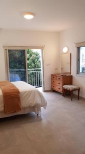ein Schlafzimmer mit einem Bett, einer Kommode und einem Fenster in der Unterkunft Polis Herb Garden in Polis Chrysochous