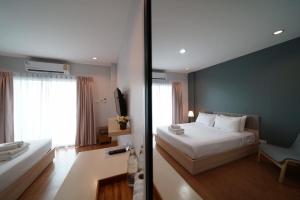 1 dormitorio con cama blanca y pared azul en Sukhothai Garden, en Sukhothai