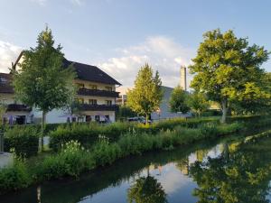 einen Fluss vor einem Gebäude mit Bäumen in der Unterkunft Hotel Schiff Nagold in Nagold