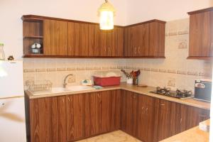 una cucina con mobili in legno e un lavello di EHolidays Villa a Pereybere