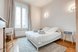 Habitación blanca con cama y escritorio en Maison bourgeoise Haussmannienne - Gîtes de France en Limoges