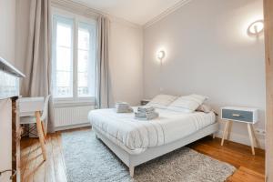 a white bedroom with a bed and a desk at Maison bourgeoise Haussmannienne - Gîtes de France in Limoges
