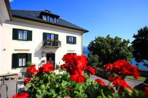 a white house with red flowers in front of it at Villa Margarethe in Millstatt