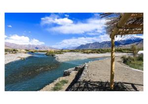 a river in the middle of a desert with mountains at The Indus River Camp in Leh