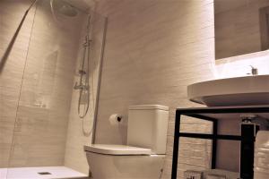 a bathroom with a shower and a toilet and a sink at HOTEL TORRENT in L'Escala