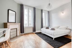 una camera con letto, scrivania e specchio di Maison bourgeoise Haussmannienne - Gîtes de France a Limoges