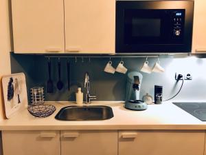 a kitchen counter with a sink and a microwave at Petit studio cosy in Bobigny