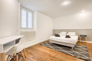 a white bedroom with a bed and a desk at Maison bourgeoise Haussmannienne - Gîtes de France in Limoges +3 photos