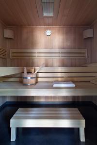 un sauna avec un banc et une horloge sur le mur dans l'établissement Chateau De La Resle - Design Hotels, à Montigny-la-Resle