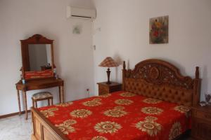 una camera da letto con un letto con un piumone rosso e uno specchio di EHolidays Villa a Pereybere Altre 25 foto