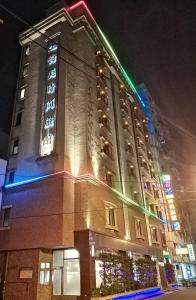 a large building with a lit up tower at night at Chimei Fashion Hotel in Zhongli