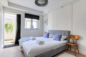 a bedroom with a large white bed with blue pillows at Luxurious ground floor apartment with patio in Amsterdam