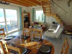 a living room with a table and chairs and a staircase at La Villa 05 in Chorges