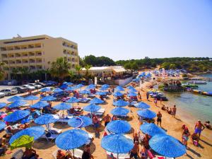ディディムにあるタンタス ビーチ ホテル オールインクルーシブの浜辺の青傘を持つ人々