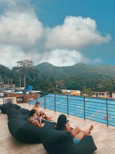 a group of women laying on the edge of a swimming pool at Indie Hostel - Koh Tao in Koh Tao