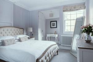 a white bedroom with a large bed and a mirror at Beautiful Apartment, incredible central location in Bath